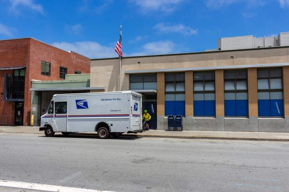 USPS delivery truck passing by a school