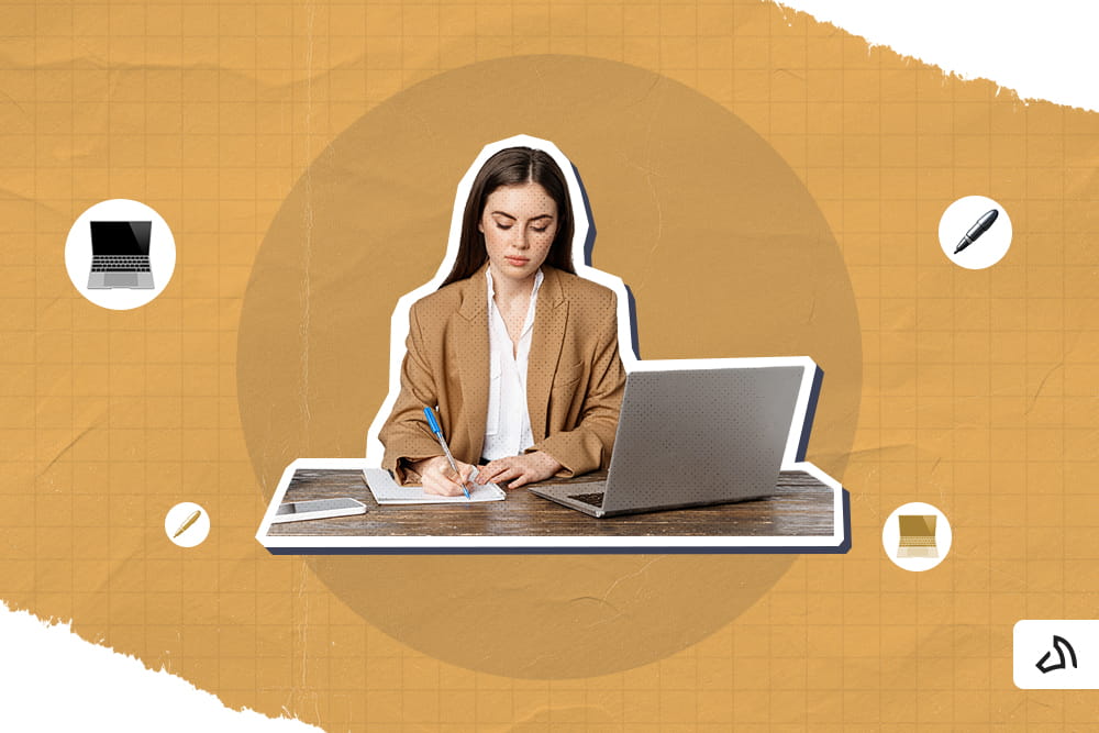A woman wearing a suit writing on a piece of paper with a laptop in front
