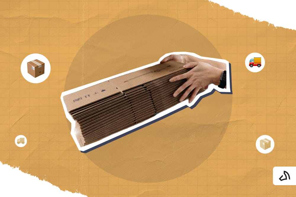 A pair of hands holding some unassembled boxes